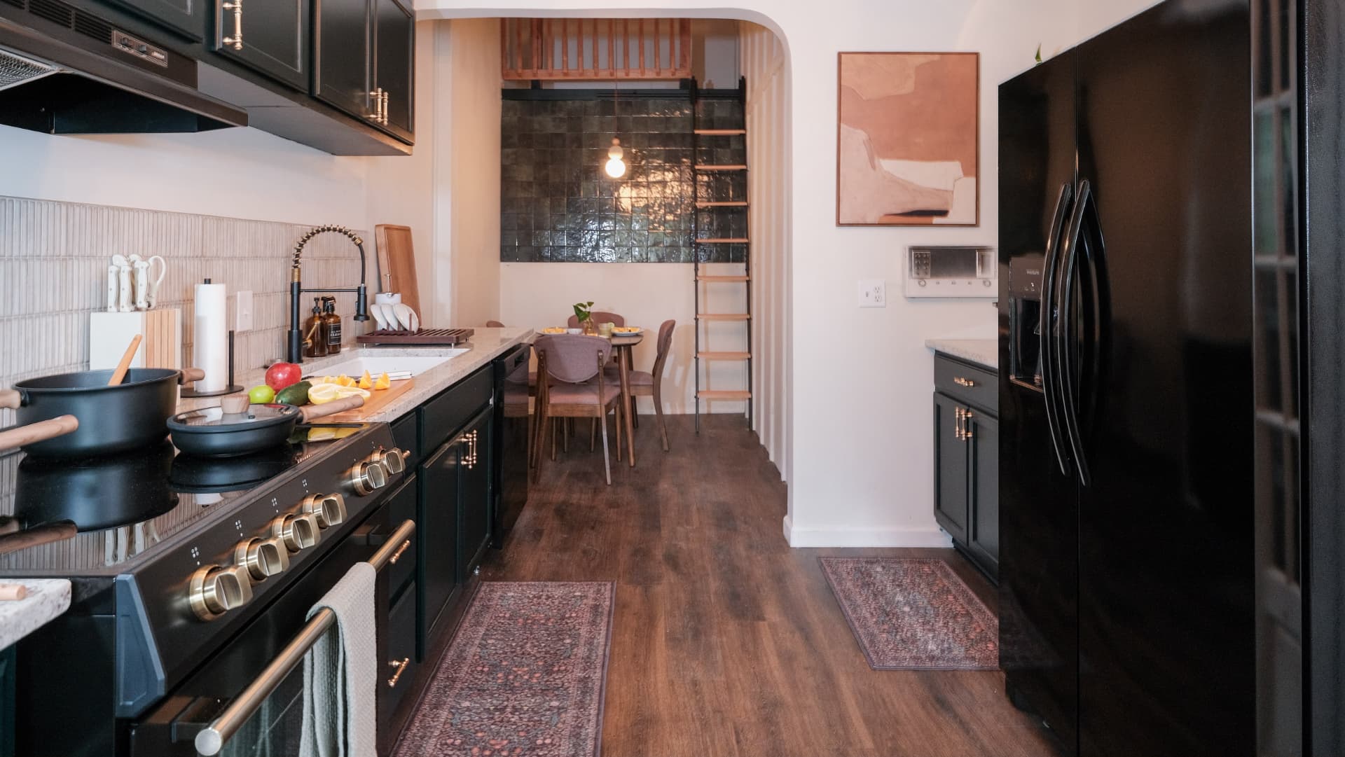 Black-cabinet kitchen with dining nook and loft ladder at the Colorado retreat house